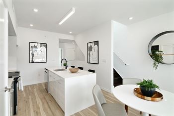 A white kitchen with a table and chairs.
